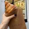 Croissant i brun papirpose trykt med "CAFE RED"-logo