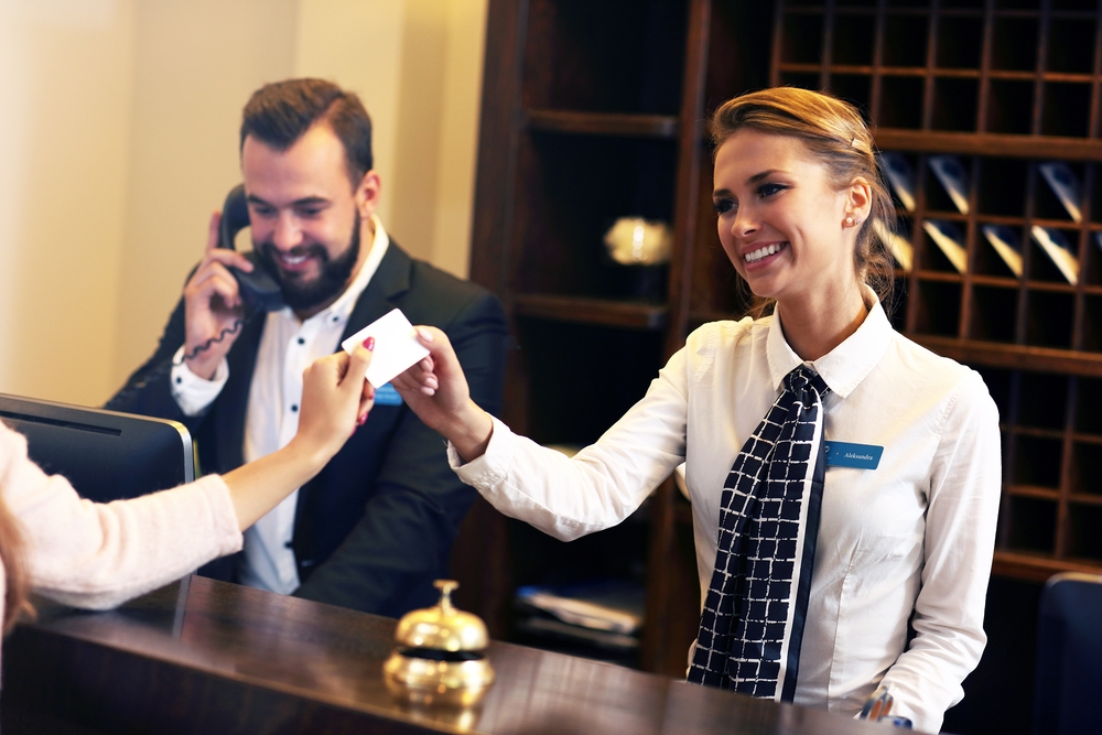 hotel receptionist giving guest key card