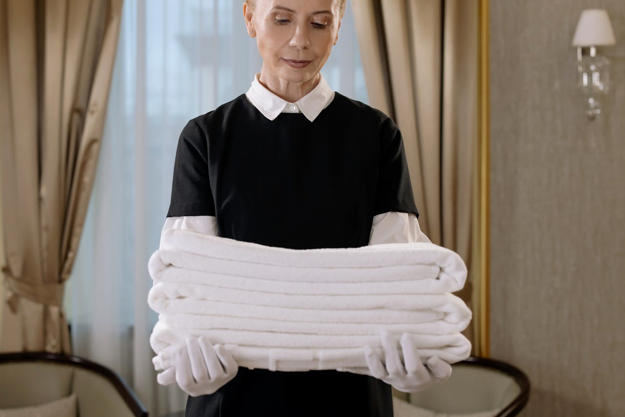 Hote Room Attendant Holding a Stack of Towels