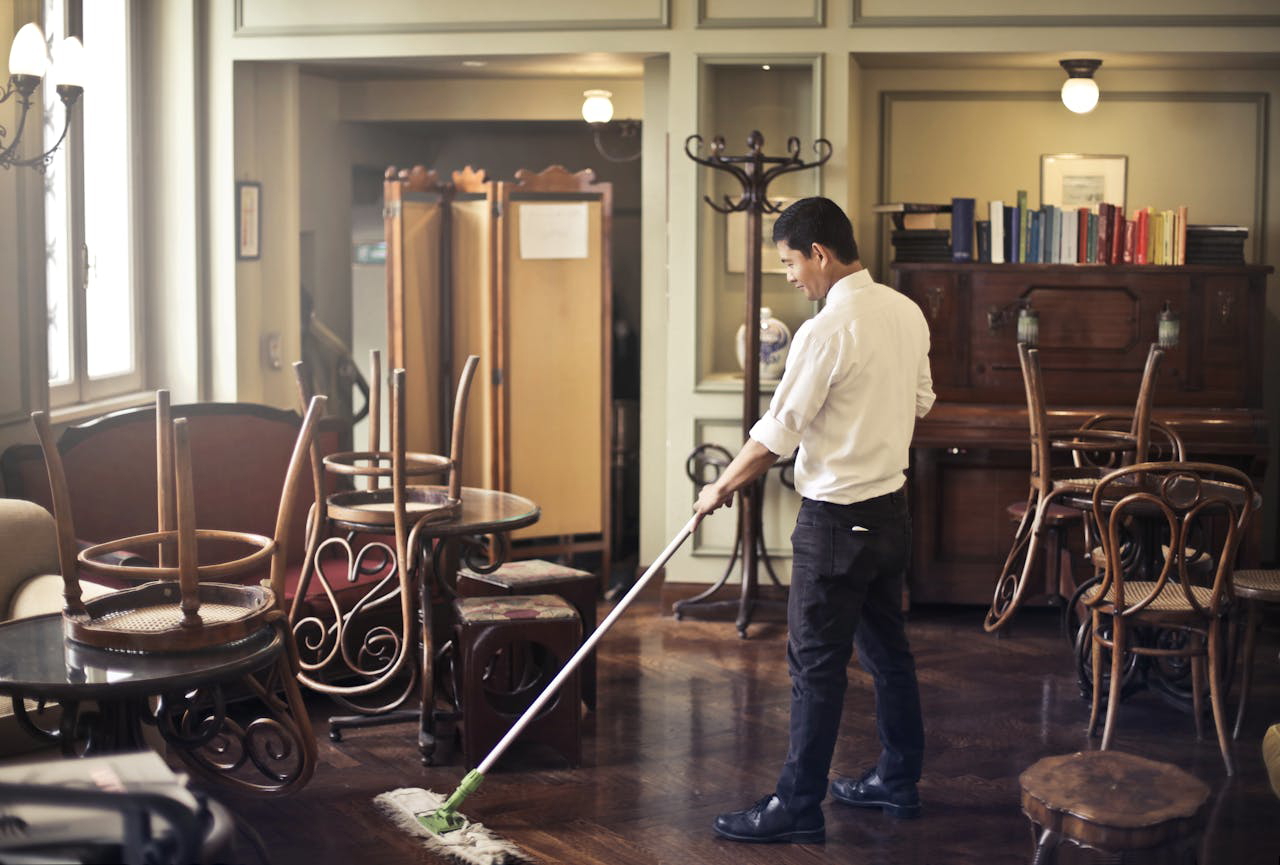 hotel employee cleaning floor in restaurant