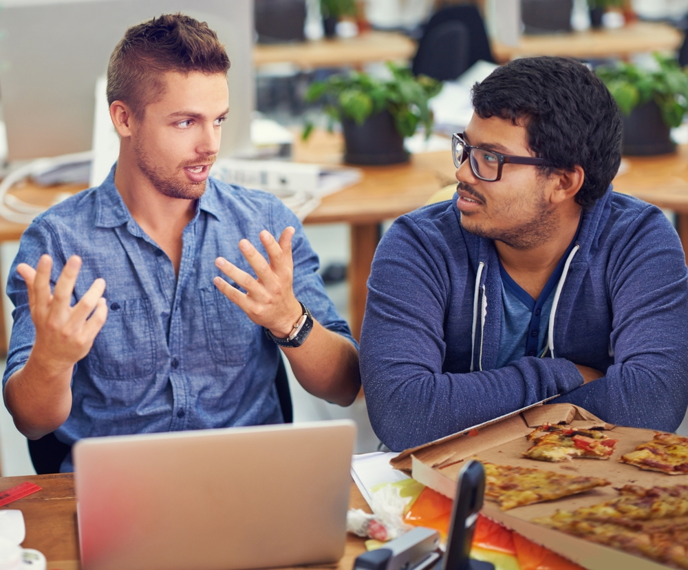 men discussing pizza business plan and eating pizza