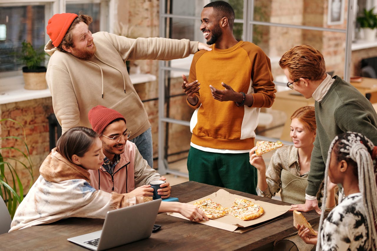 Group of People by the Table Eating Pizza