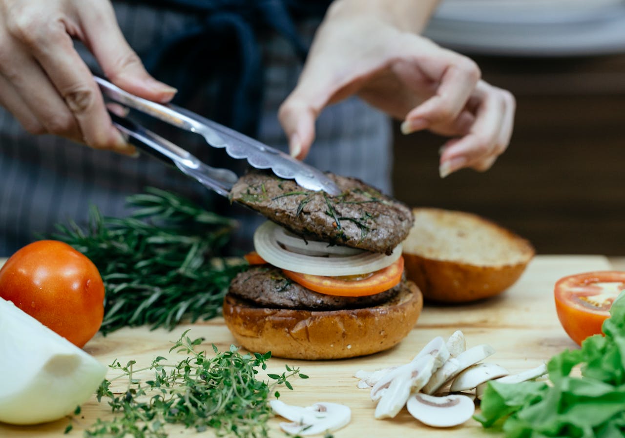 woman making burger in kitchen