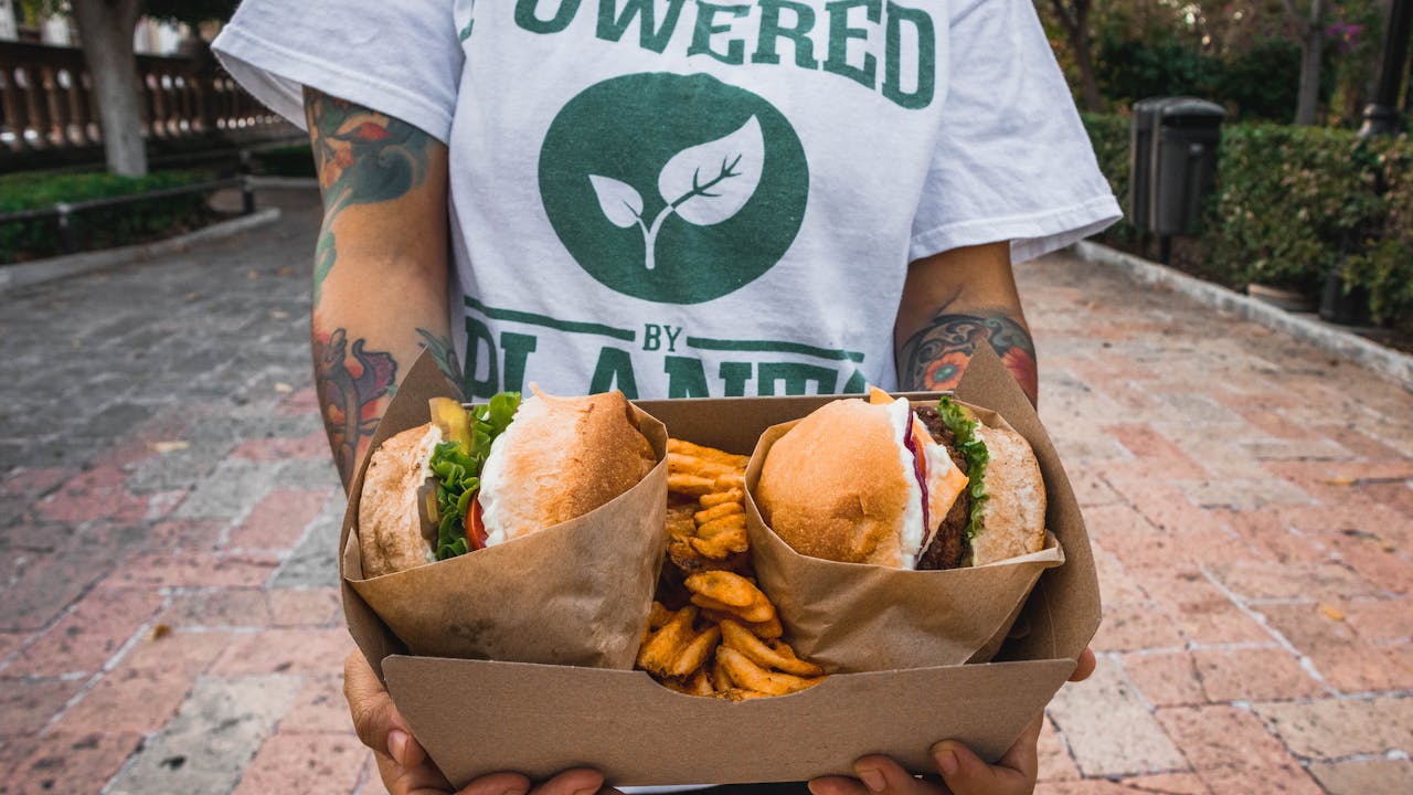 Boost Burger Joint Sales with Vegan Options | Limepack A Person Holding a Vegan Food on a Takeout Box