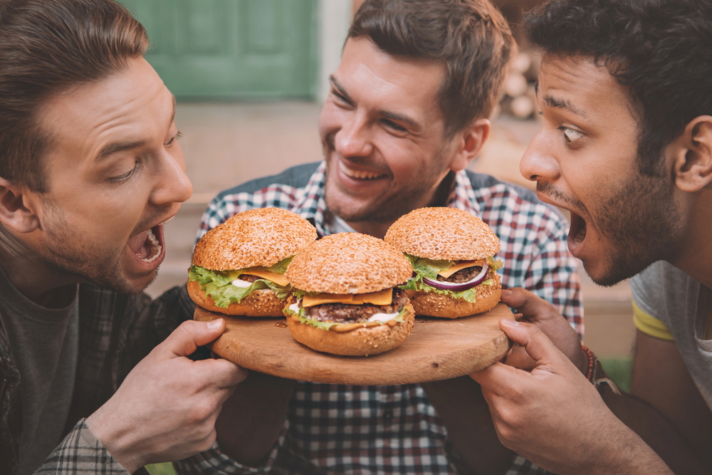 young men holding burger