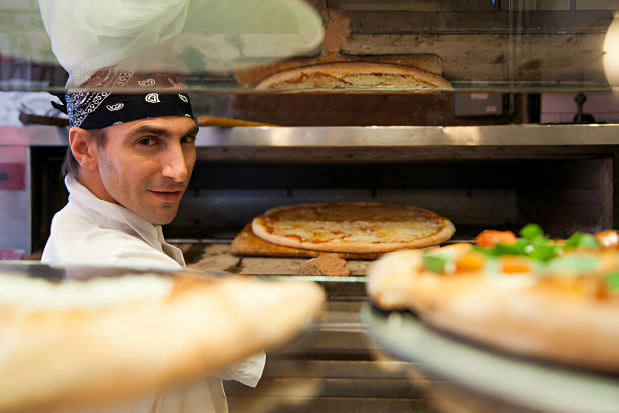 a happy pizza shop owner