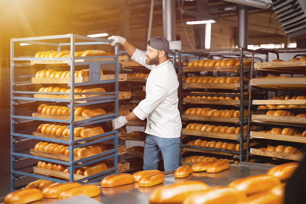 baker carries rack of bread