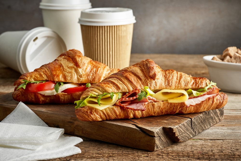 croissant sandwiches and coffee paper cups