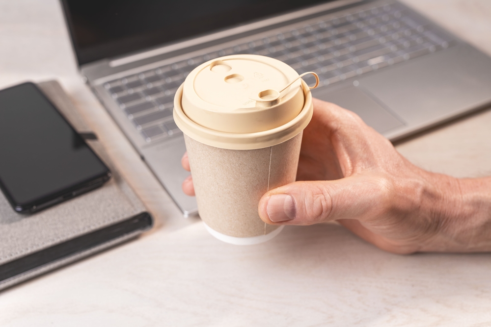 man holding beige takeaway paper cup