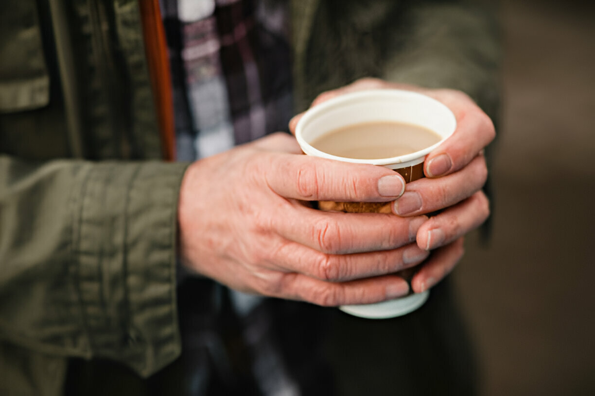 man warming up with a cup of coffee