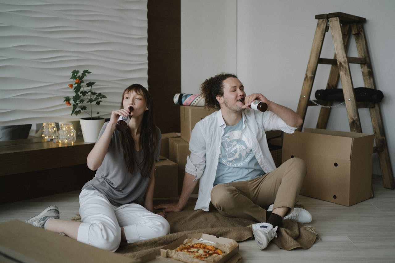 Man and Woman Drinking Beer and Eating Pizza Together