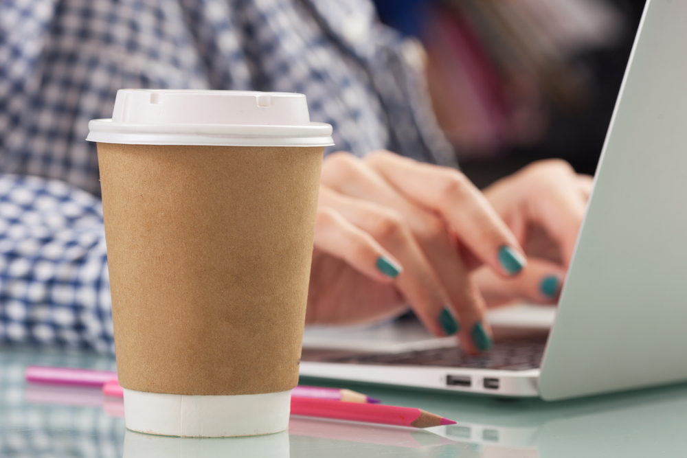 woman drinking coffee with a disposable paper cup