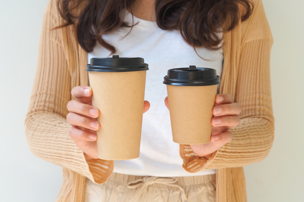 woman hand holding coffee paper cups