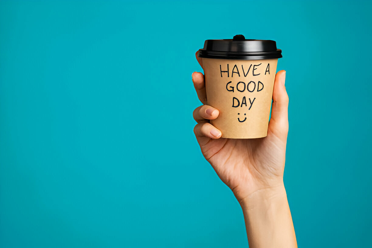 woman holding morning coffee paper cup