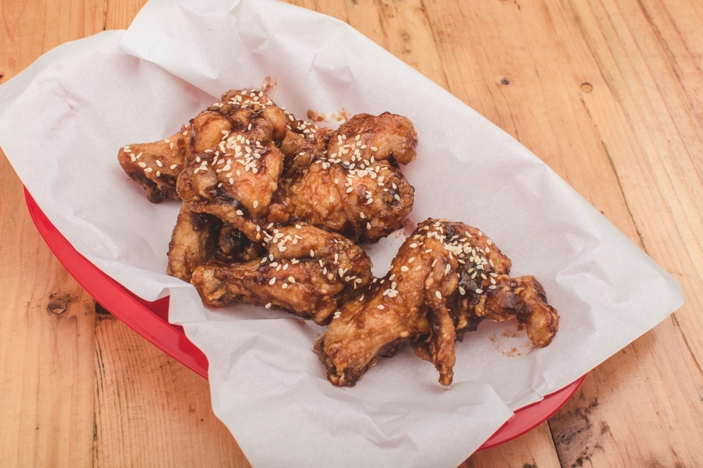 spicy korean chicken wings served on greaseproof paper