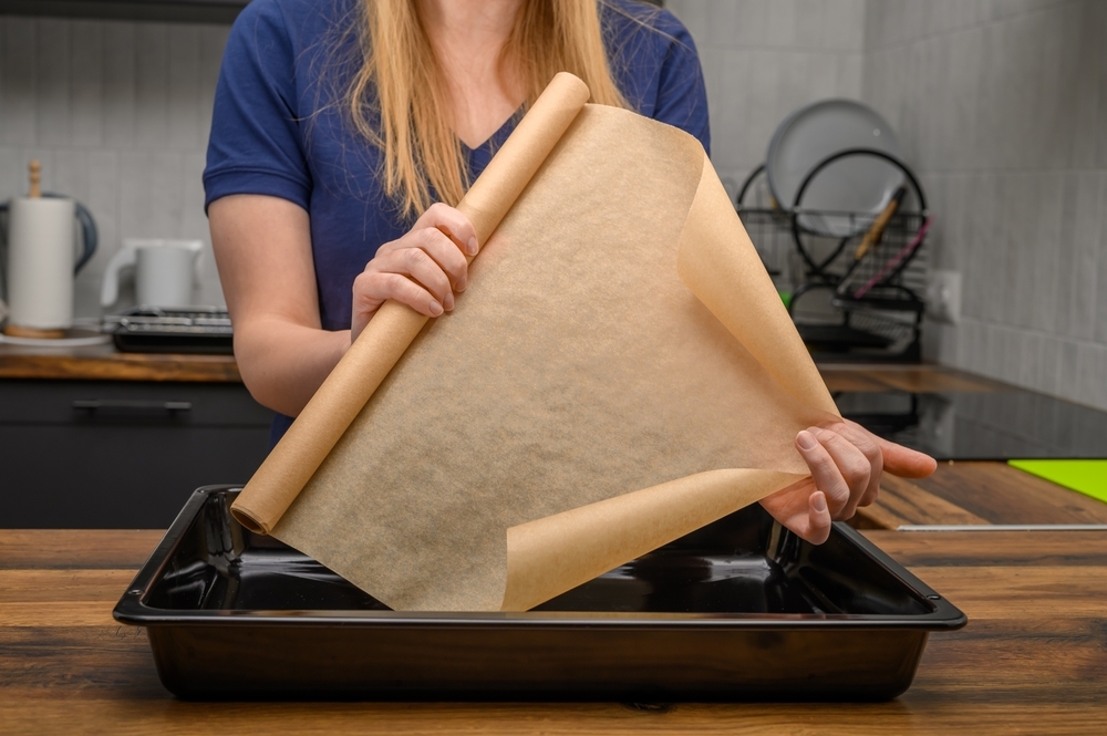 woman holds roll of brown baking paper