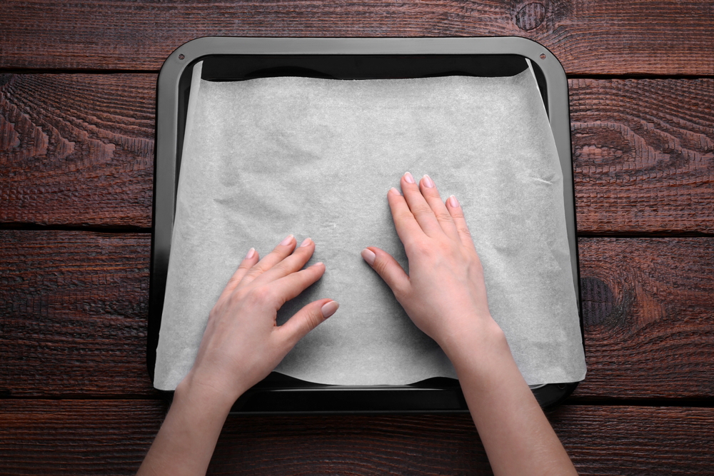 woman putting greaseproof paper in baking pan